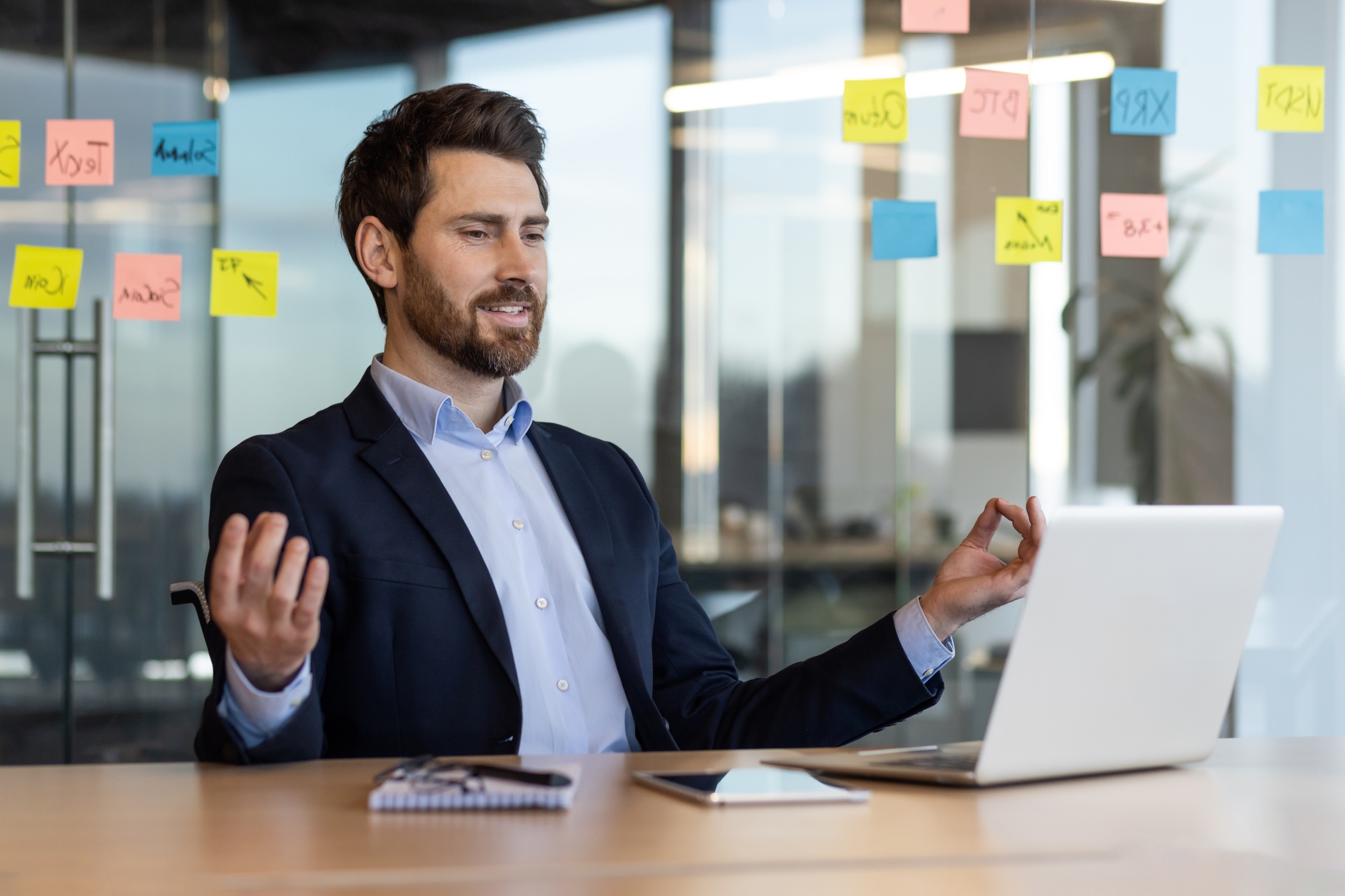 Businessman practicing mindfulness at the office desk for stress relief in modern workplace