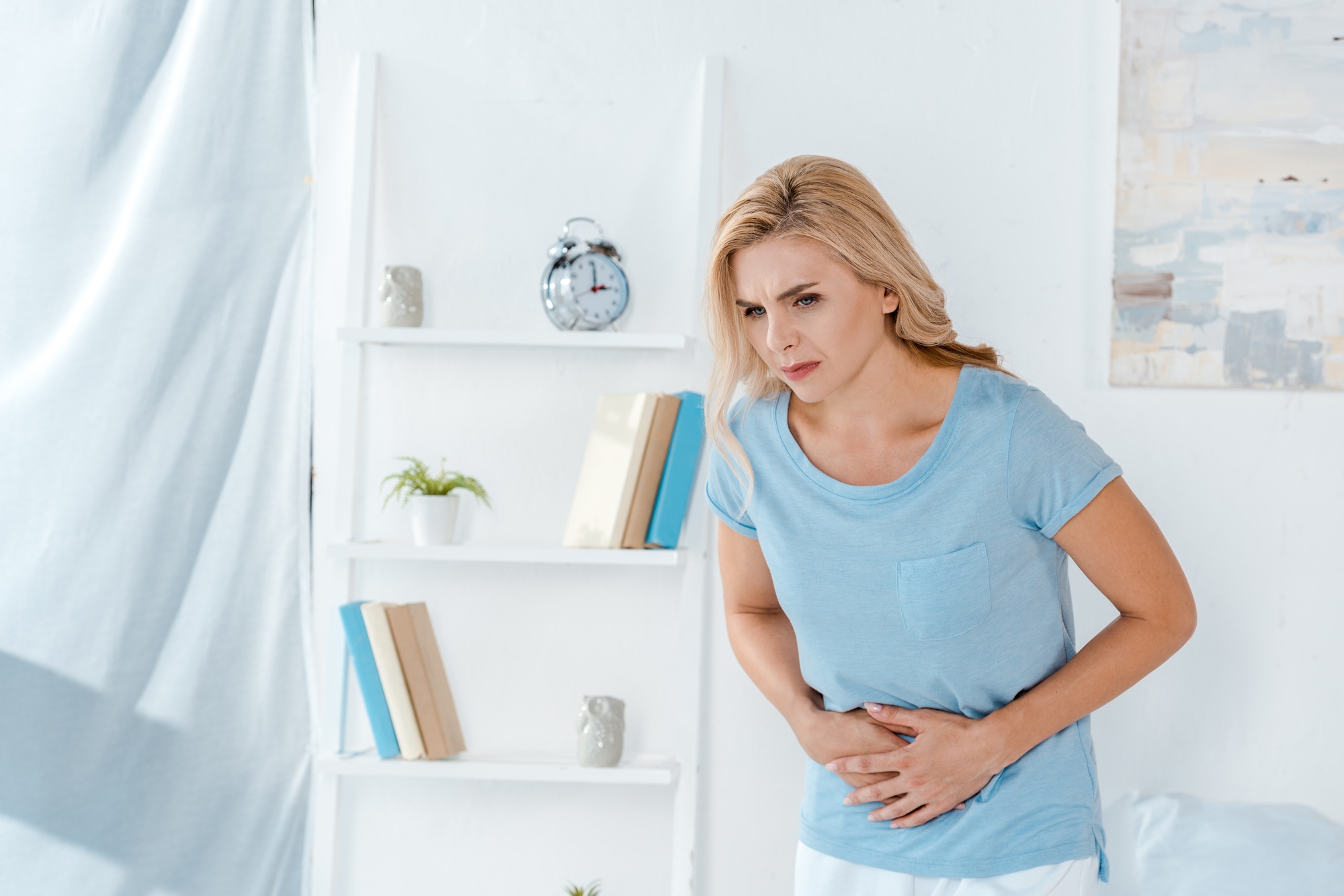sick woman having stomach ache at home